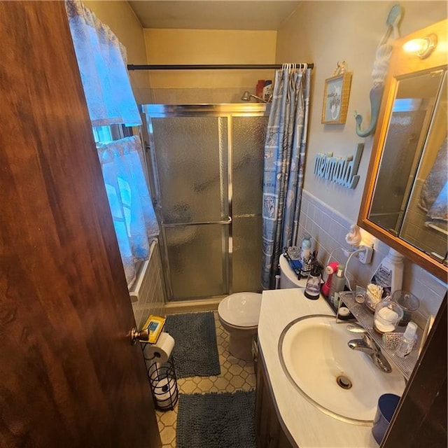 bathroom with toilet, vanity, and a shower with shower door