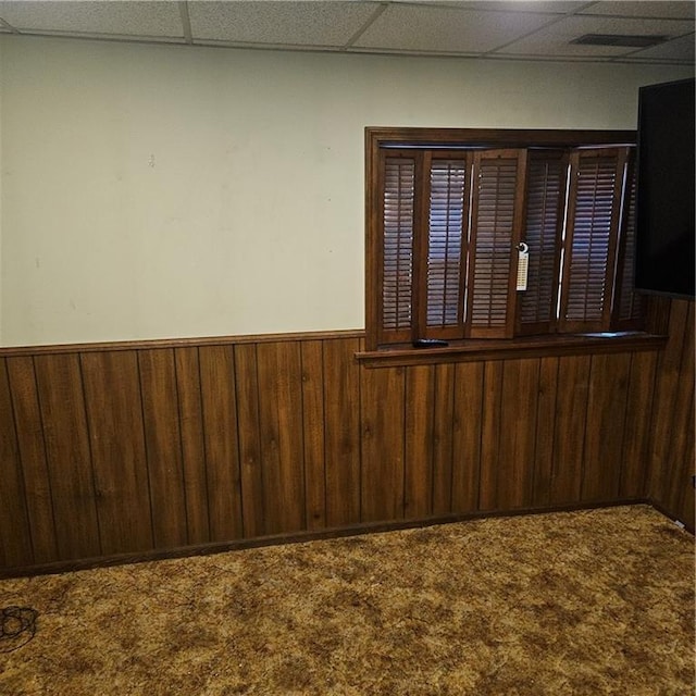 carpeted spare room featuring a paneled ceiling