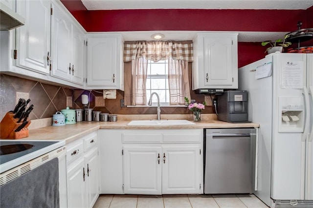 kitchen featuring white appliances, sink, backsplash, and white cabinetry