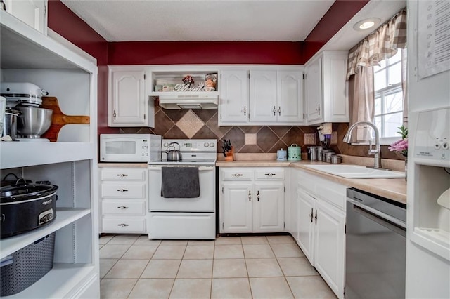 kitchen featuring sink, white appliances, white cabinetry, and light tile patterned floors