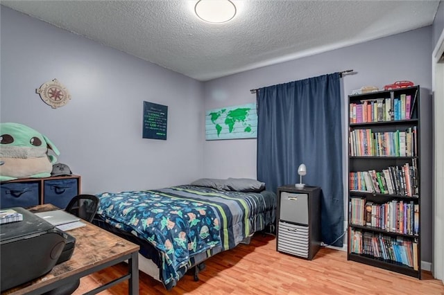 bedroom with hardwood / wood-style flooring and a textured ceiling