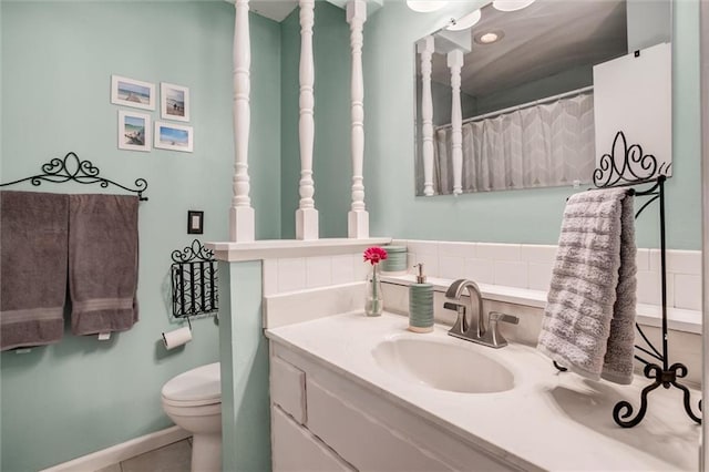 bathroom with tile patterned flooring, vanity, and toilet