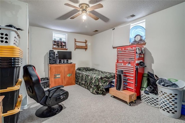 carpeted bedroom featuring a textured ceiling and ceiling fan