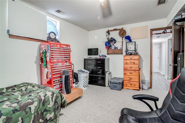 bedroom with ceiling fan, light colored carpet, and a textured ceiling