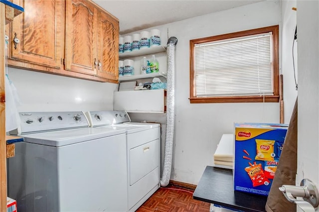 laundry area with dark parquet floors, cabinets, and independent washer and dryer