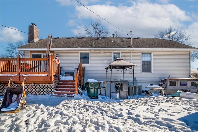 snow covered house featuring a deck and a gazebo