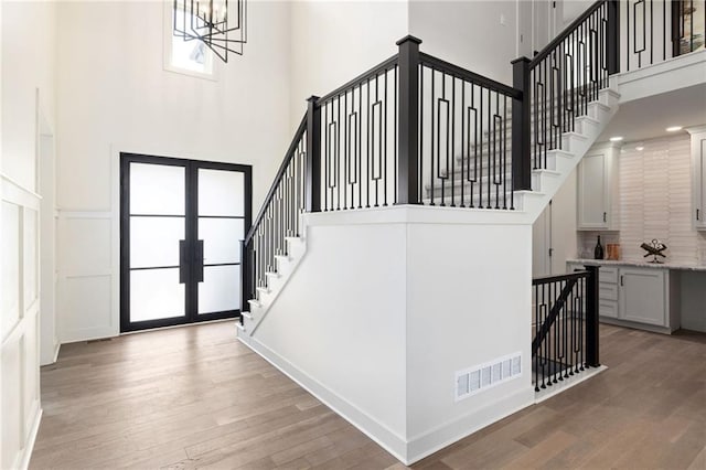 2210 NW Palisades Dr, Riverside, MO 64150 - foyer featuring visible vents, a high ceiling, light wood-style floors, stairs, and french doors