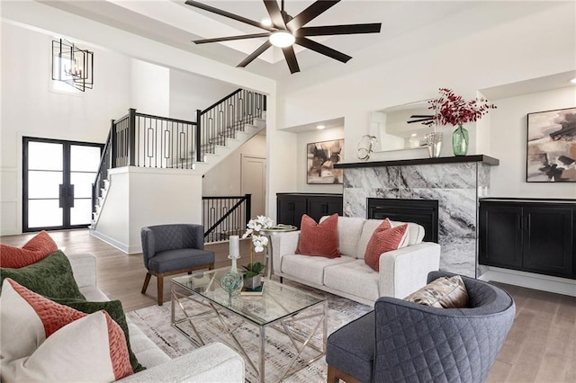 2210 NW Palisades Dr, Riverside, MO 64150 - living area featuring stairway, wood finished floors, a towering ceiling, and a ceiling fan