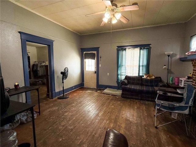 living room featuring ceiling fan, ornamental molding, and dark hardwood / wood-style floors