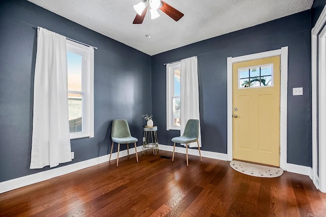 entryway featuring ceiling fan, a textured ceiling, and dark hardwood / wood-style floors