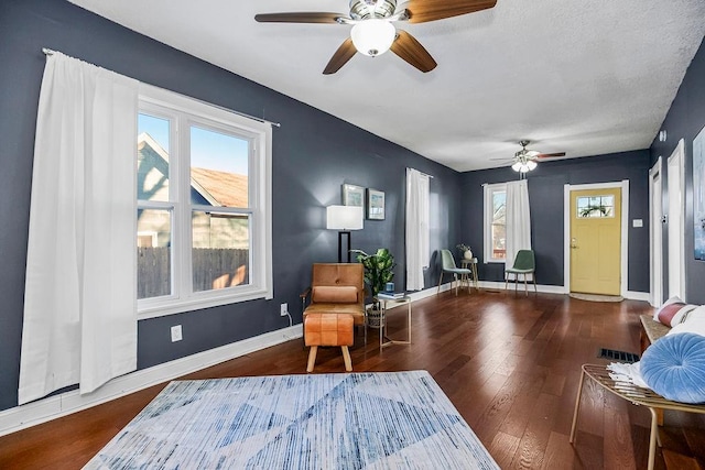 living area with wood-type flooring, ceiling fan, and a healthy amount of sunlight