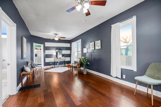 interior space with ceiling fan, a textured ceiling, and wood-type flooring