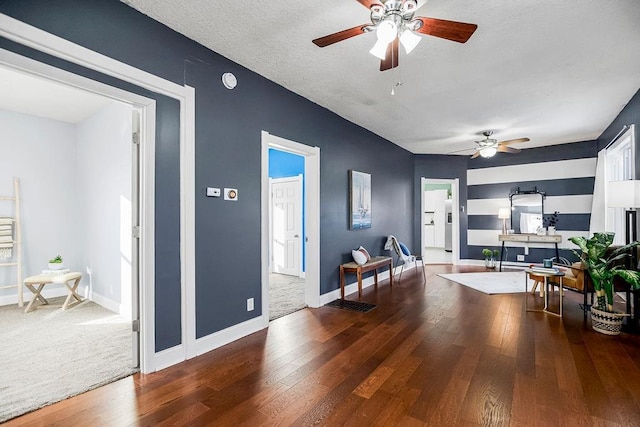 living room with a textured ceiling, ceiling fan, and hardwood / wood-style floors