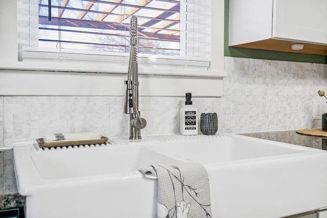 details featuring tasteful backsplash and white cabinetry