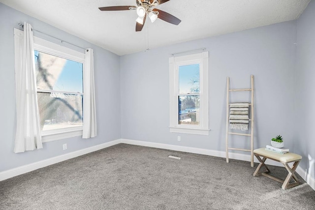 carpeted spare room featuring ceiling fan