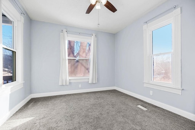 carpeted empty room with ceiling fan and a healthy amount of sunlight