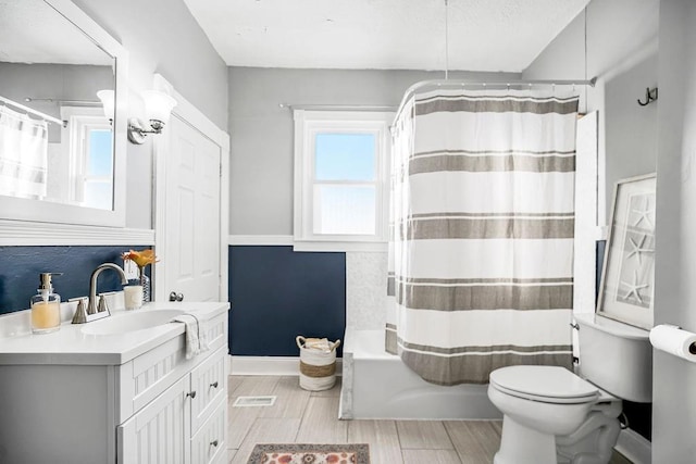 full bathroom with shower / tub combo, vanity, and toilet