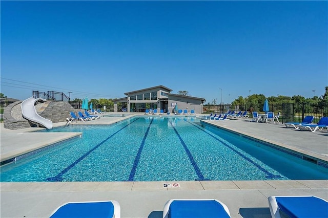 view of swimming pool featuring a water slide and a patio area