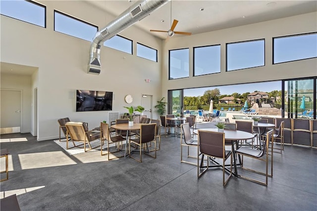 dining room with a high ceiling and ceiling fan