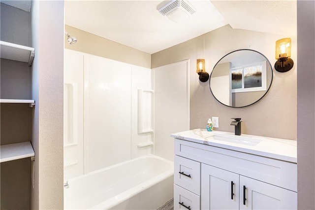 bathroom featuring washtub / shower combination and vanity