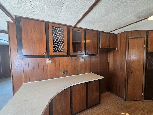 kitchen featuring wood-type flooring and wood walls