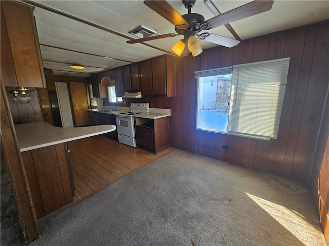 kitchen featuring kitchen peninsula, white electric range oven, carpet flooring, ceiling fan, and sink