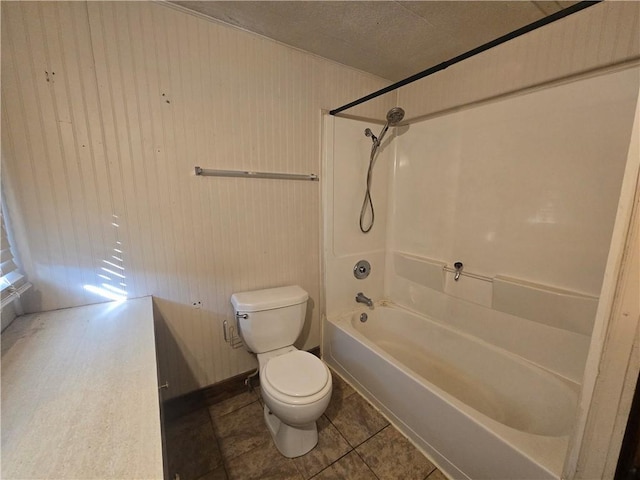 bathroom with shower / bathtub combination, wooden walls, tile patterned floors, and toilet