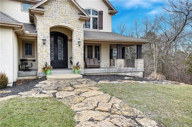 view of front of home with a front yard, covered porch, and french doors