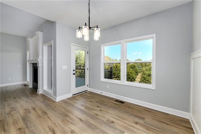 unfurnished dining area with light hardwood / wood-style flooring and a chandelier