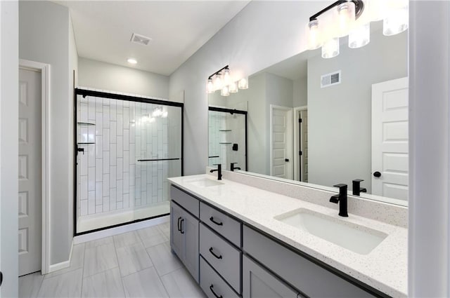 bathroom featuring a shower with door, vanity, and tile patterned floors