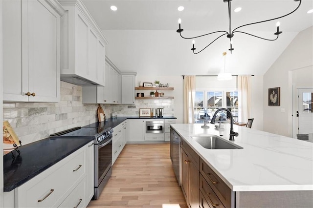 kitchen with sink, white cabinetry, lofted ceiling, hanging light fixtures, and appliances with stainless steel finishes