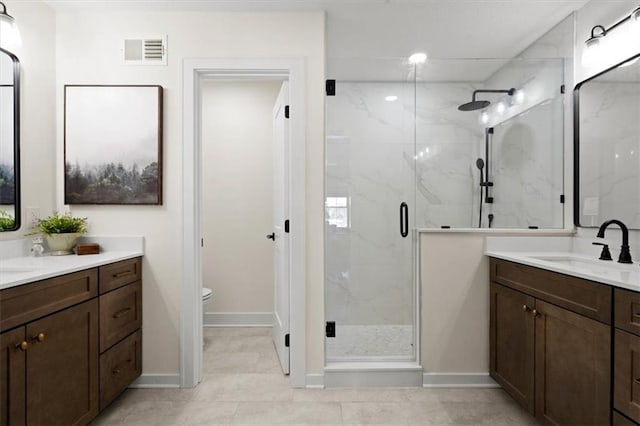 bathroom featuring toilet, tile patterned flooring, an enclosed shower, and vanity