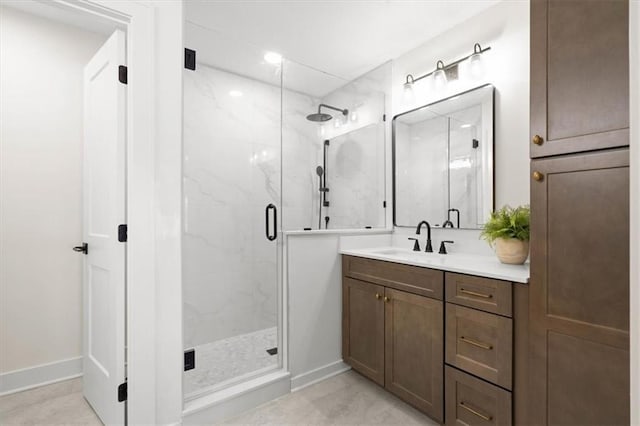 bathroom featuring a shower with door and vanity