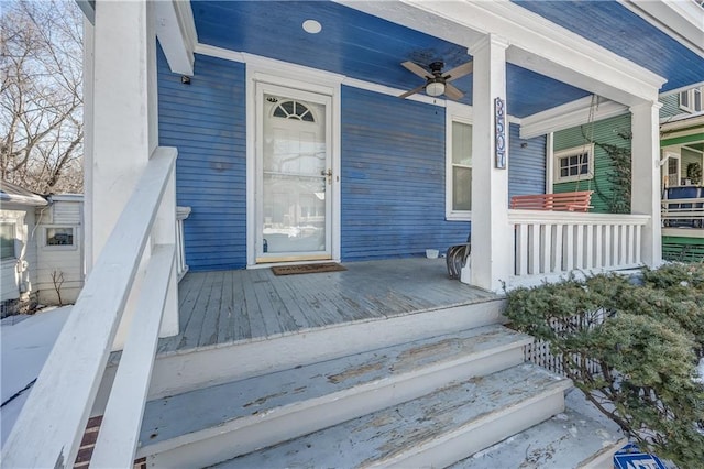 view of exterior entry featuring a porch and ceiling fan