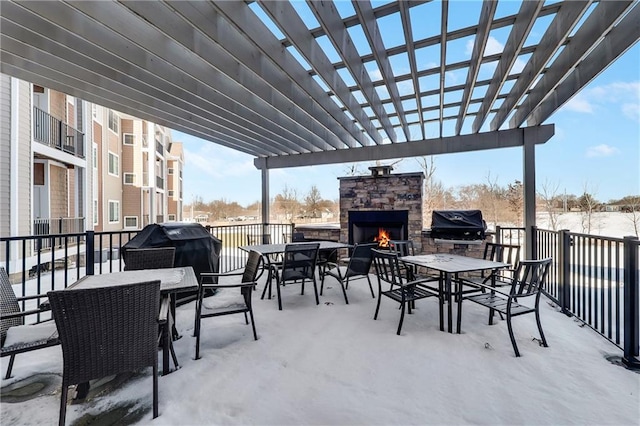 view of patio featuring area for grilling, a pergola, and an outdoor stone fireplace