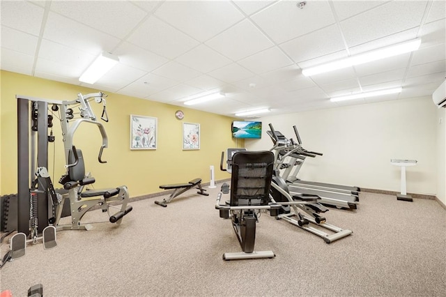 gym with a paneled ceiling and a wall unit AC