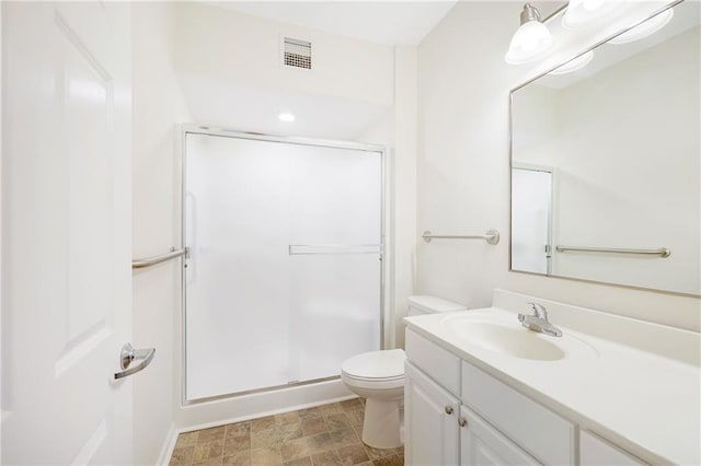 bathroom featuring an enclosed shower, vanity, and toilet