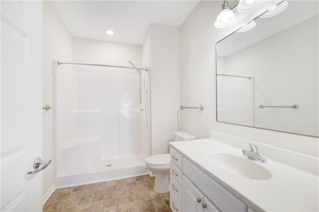 bathroom featuring toilet, vanity, and walk in shower