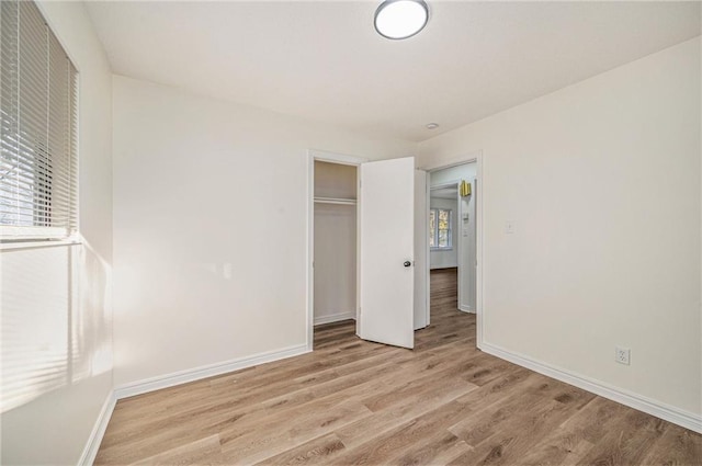 unfurnished bedroom with a closet and light hardwood / wood-style floors