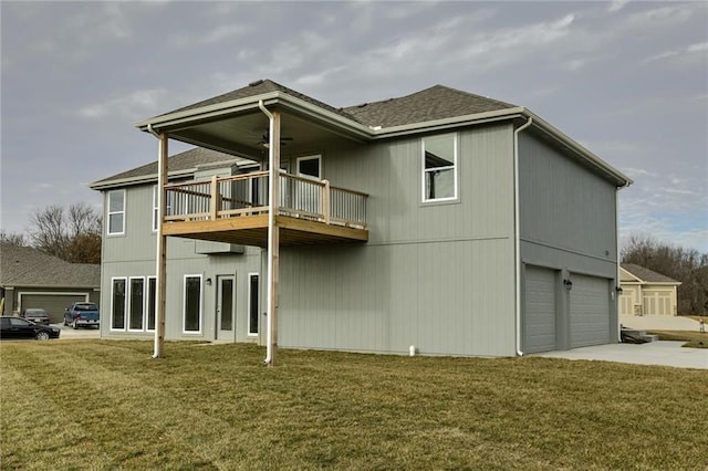 back of property featuring a lawn, concrete driveway, a garage, and roof with shingles