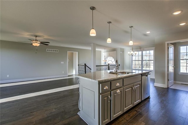 kitchen with visible vents, a center island with sink, a sink, dark wood-style floors, and dishwasher