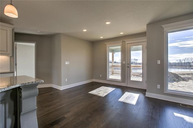 interior space featuring dark wood finished floors, visible vents, and baseboards