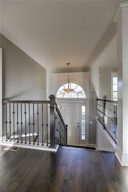 foyer featuring visible vents, baseboards, and hardwood / wood-style floors