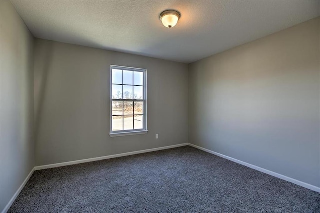 carpeted spare room featuring baseboards and a textured ceiling