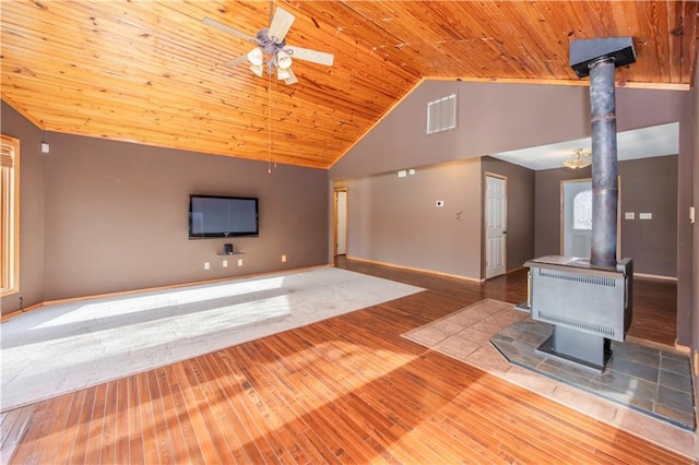 unfurnished living room with hardwood / wood-style floors, ceiling fan, a wood stove, high vaulted ceiling, and wooden ceiling