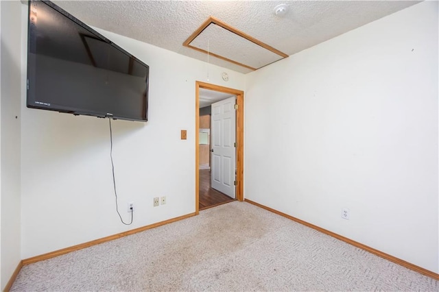 spare room featuring a textured ceiling and carpet flooring