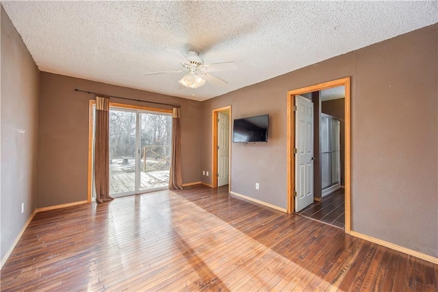 empty room with ceiling fan, a textured ceiling, and dark hardwood / wood-style flooring