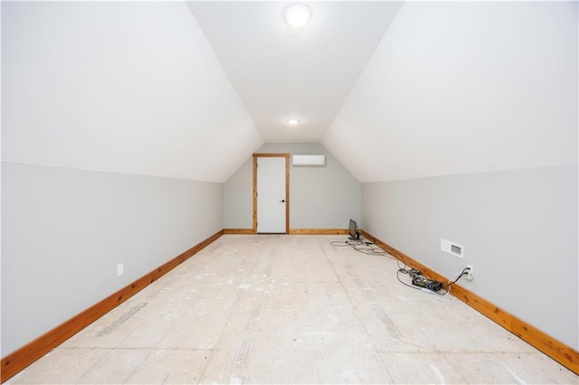 bonus room with lofted ceiling and an AC wall unit