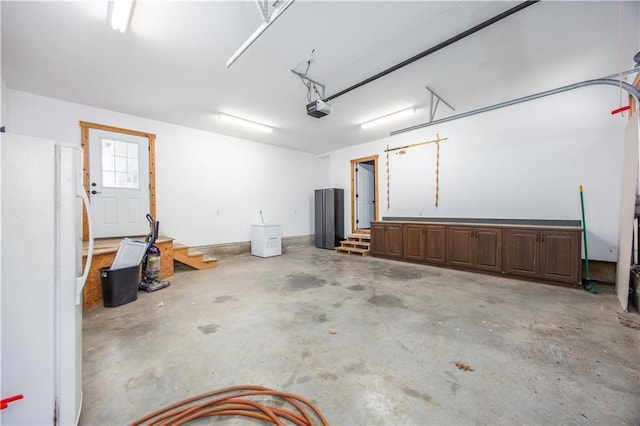 garage with white fridge and a garage door opener