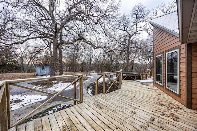 snow covered deck featuring a storage shed